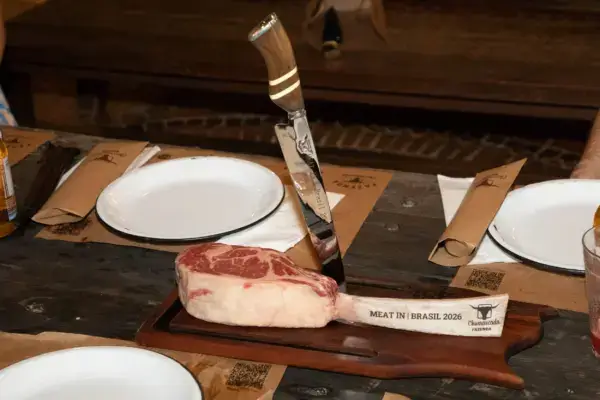 Ein Tomahawk-Steak – roh, noch ungegrillt – präsentiert auf einem Holzbrett